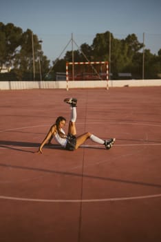 An impressive athlete showcases remarkable flexibility and athleticism while on a sunlit outdoor sports court area