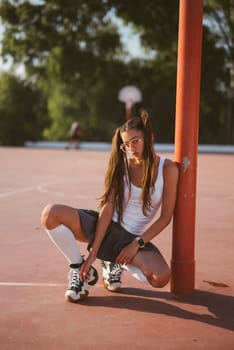 A lively young girl joyfully plays on a bright basketball court, showcasing her athleticism and style
