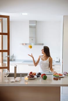A woman is skillfully demonstrating the preparation of healthy food in a stylish, modern kitchen environment