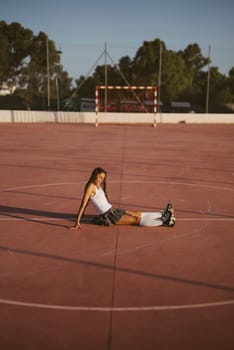 A young woman is happily roller skating on a sunny outdoor court, fully embodying the spirit of freedom and fun