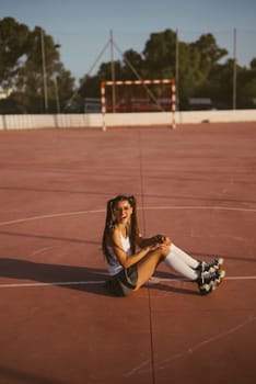 A stylish and fashionable roller skater is seated on the court, perfectly showcasing both style and leisure activities