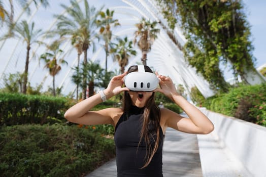 A joyful woman in a stylish VR headset is surrounded by vibrant palm trees, embodying adventure and tech