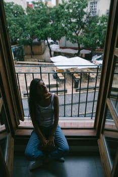 A reflective and introspective individual sits peacefully by the window, capturing the intricate essence of urban life