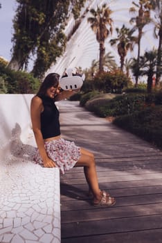 A fashionable woman takes pleasure in the beauty of nature while strolling through a serene, modern park setting