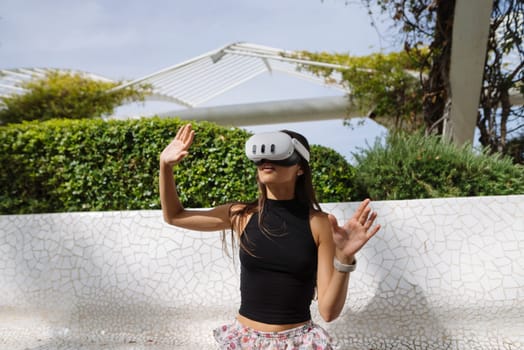 A young woman actively engaged with groundbreaking virtual reality technology in a serene and beautiful outdoor setting