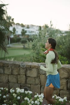 A woman jogs in a beautiful landscape, showcasing her commitment to a healthy lifestyle and fitness