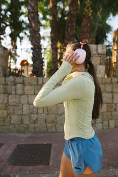 A young woman enjoys a peaceful outdoor walk, listening to her favorite music through headphones, amidst nature