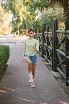 A fashionable young woman leisurely walks outdoors on a bright sunny day, proudly showcasing her relaxed look