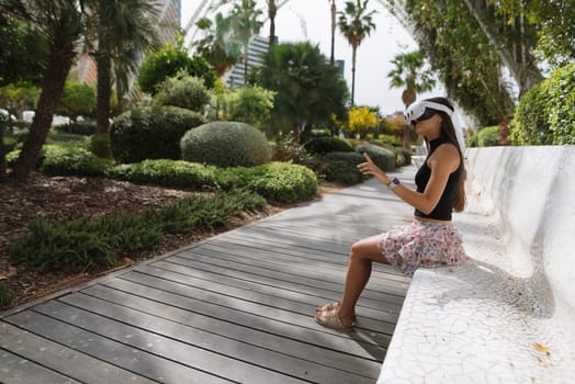 A woman finds happiness as she enjoys a peaceful moment outdoors, enveloped by vibrant greenery in a stylish setting