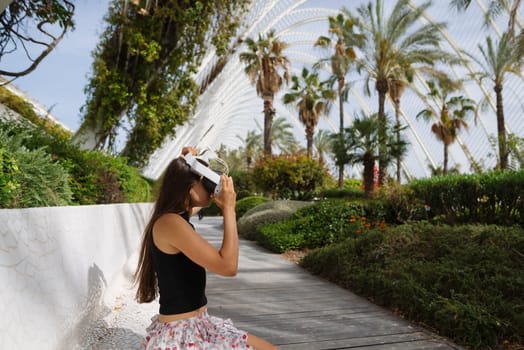 A young woman takes a journey through a vibrant, lush garden while donning a virtual reality headset