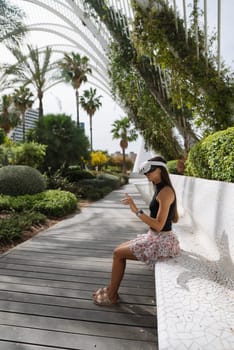 A young woman is happily enjoying a serene and peaceful moment in a vibrant lush garden filled with tropical plants