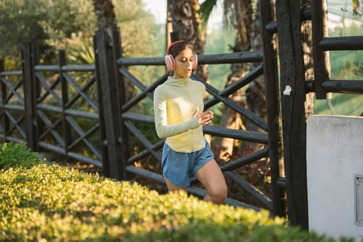 A joyful girl playfully running in a beautiful park, showcasing a trendy outfit against lush, green scenery