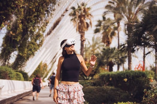 A stylish, confident young woman strolls gracefully amidst the lush, vibrant greenery and swaying palm trees