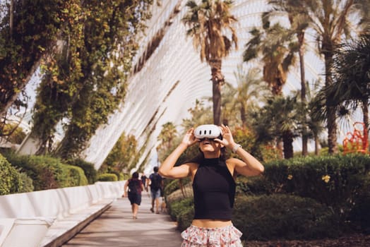 A fashionable woman enjoying her vibrant urban surroundings with cheerful palm trees and sleek buildings