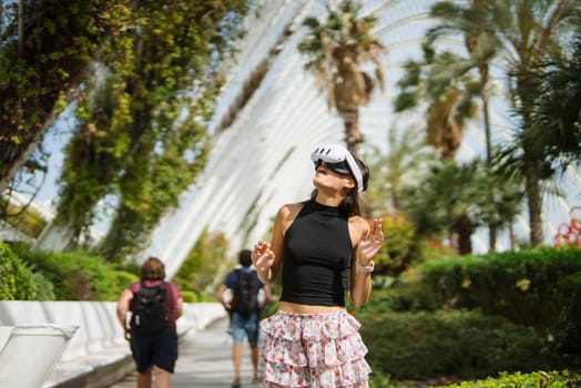 A trendy young woman poses confidently amidst the lush tropical greenery in a highly vibrant environment