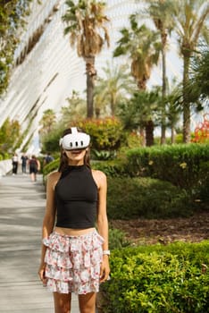 A young woman wears a VR headset, immersed in a lush, palmfilled environment, blending technology and nature