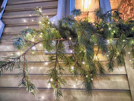 Festive pine branches adorned with twinkling lights enhance the charm of a home during the holiday season.