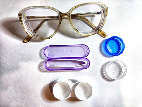 Set for contact lenses with a container, forceps, glasses. The concept of correcting myopia. Contact lens care, cleaning, health. Background, copy space