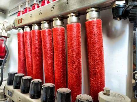 Bright red fire hoses are organized and stored in a fire station, ready for immediate use in emergencies.