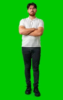 A young man with a beard showing a serious expression against a vibrant green background close up