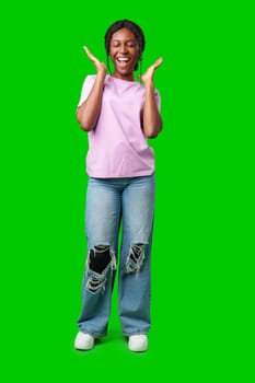 Young woman smiling joyfully in a pink shirt against a vibrant green background in a cheerful atmosphere close up