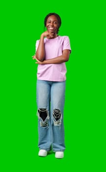Young woman smiling joyfully in a pink shirt against a vibrant green background in a cheerful atmosphere close up