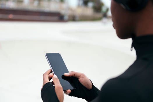 crop of the hands of an anonymous ethnic female text messaging on mobile phone with black screen in city, concept of technology of communication
