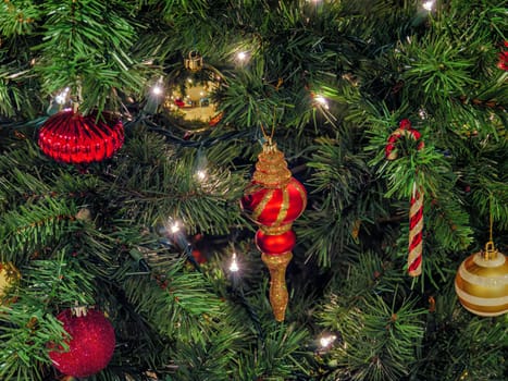 Decorating color balls in halo of electric lights among brenches of artificial Christmas tree