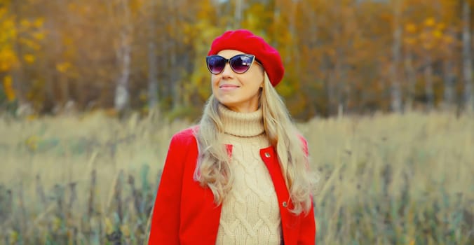 Autumn portrait of beautiful happy mature woman in red french beret hat, jacket, glasses, looking away outdoors