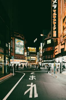 TOKYO, JAPAN - MAY 12 2019: Neon signs illuminate Tokyo’s busy Shinjuku neighborhood at night around Yodobashi camera store