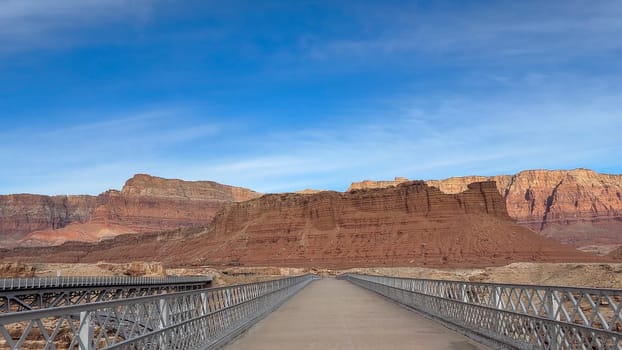 View across the old historic Navajo Bridge at Marble Canyon across the Colorado River. The stunning Vermillion Cliffs can be seen on the other side of the bridge - Arizona, USA