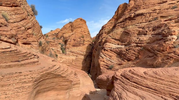 A shot of the beautiful red sandstone rock formations with stunning erosion on the trail link between Wire Pass and Buckskin Gulch canyons in Utah on a beautiful blue sky day - USA