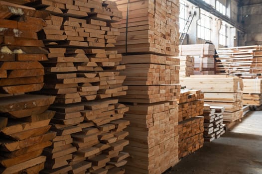 Stacked wooden planks close-up at lumber warehouse. Wood industry concept