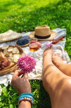 Wine in hands of woman at picnic. Selective focus. Nature.