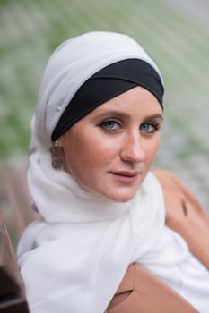 Portrait of a young blue-eyed woman in a hijab outdoors