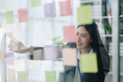 Beautiful young teen asian businesswoman using note pad thinking with planning working on financial document, tax, exchange, accounting and Financial advisor.