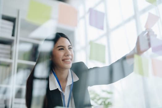 Beautiful young teen asian businesswoman using note pad thinking with planning working on financial document, tax, exchange, accounting and Financial advisor.