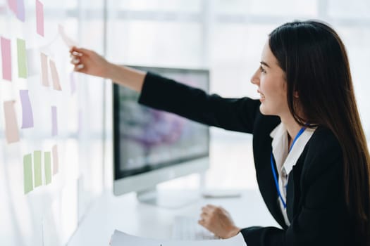 Beautiful young teen asian businesswoman using note pad thinking with planning working on financial document, tax, exchange, accounting and Financial advisor.