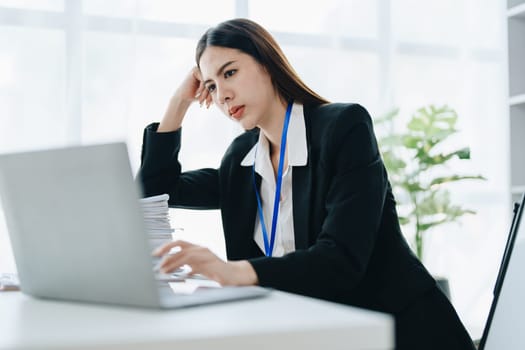 Portrait of business owner, woman using computer and financial statements Anxious expression on expanding the market to increase the ability to invest in business.