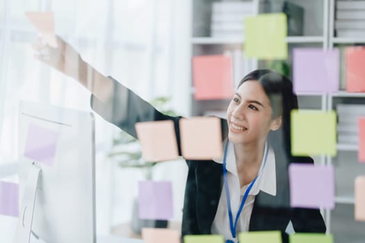 Beautiful young teen asian businesswoman using note pad thinking with planning working on financial document, tax, exchange, accounting and Financial advisor.