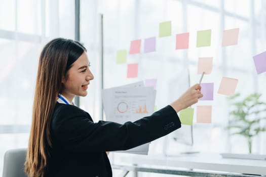 Beautiful young teen asian businesswoman using note pad thinking with planning working on financial document, tax, exchange, accounting and Financial advisor.