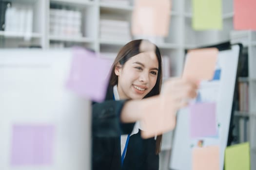 Beautiful young teen asian businesswoman using note pad thinking with planning working on financial document, tax, exchange, accounting and Financial advisor.