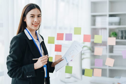 Beautiful young teen asian businesswoman using note pad thinking with planning working on financial document, tax, exchange, accounting and Financial advisor.