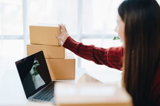 Asian female business owner handles delivery of orders to customers.