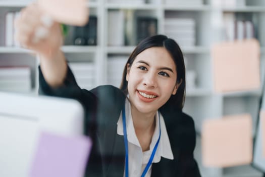 Beautiful young teen asian businesswoman using note pad thinking with planning working on financial document, tax, exchange, accounting and Financial advisor.