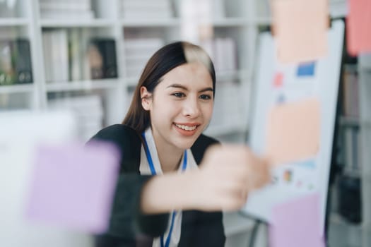 Beautiful young teen asian businesswoman using note pad thinking with planning working on financial document, tax, exchange, accounting and Financial advisor.