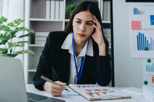 Portrait of business owner, woman using computer and financial statements Anxious expression on expanding the market to increase the ability to invest in business.