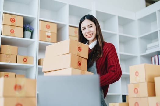 Asian female business owner handles delivery of orders to customers.