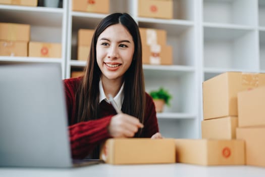 Asian female business owner handles delivery of orders to customers.