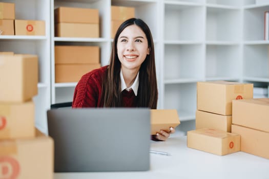 Asian female business owner handles delivery of orders to customers.